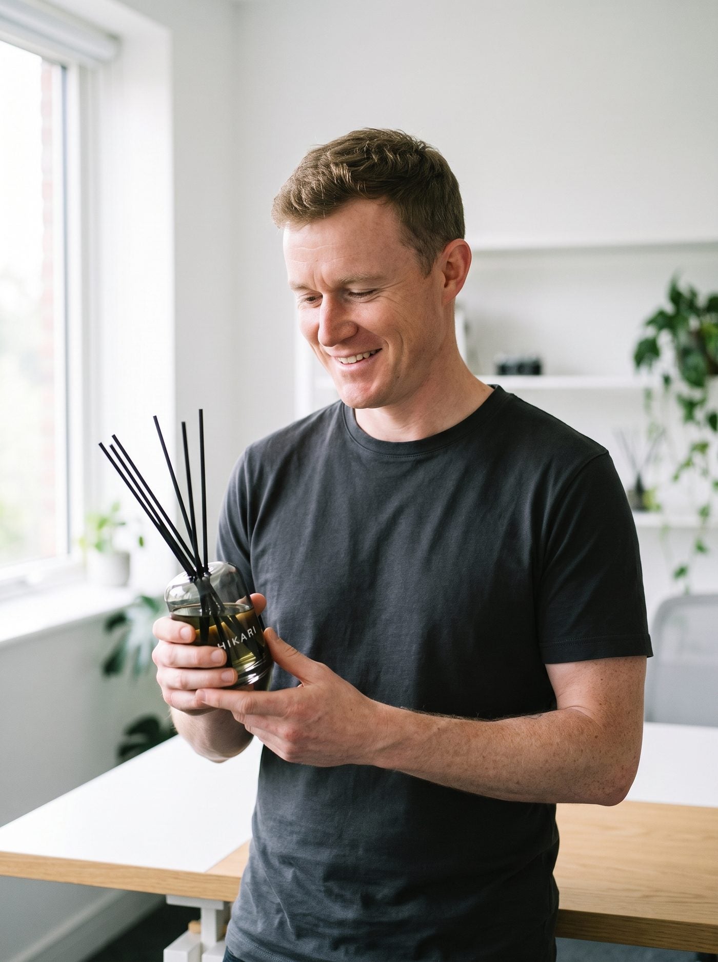 Tom Williams, founder of HIKARI, holding the MORI reed diffuser